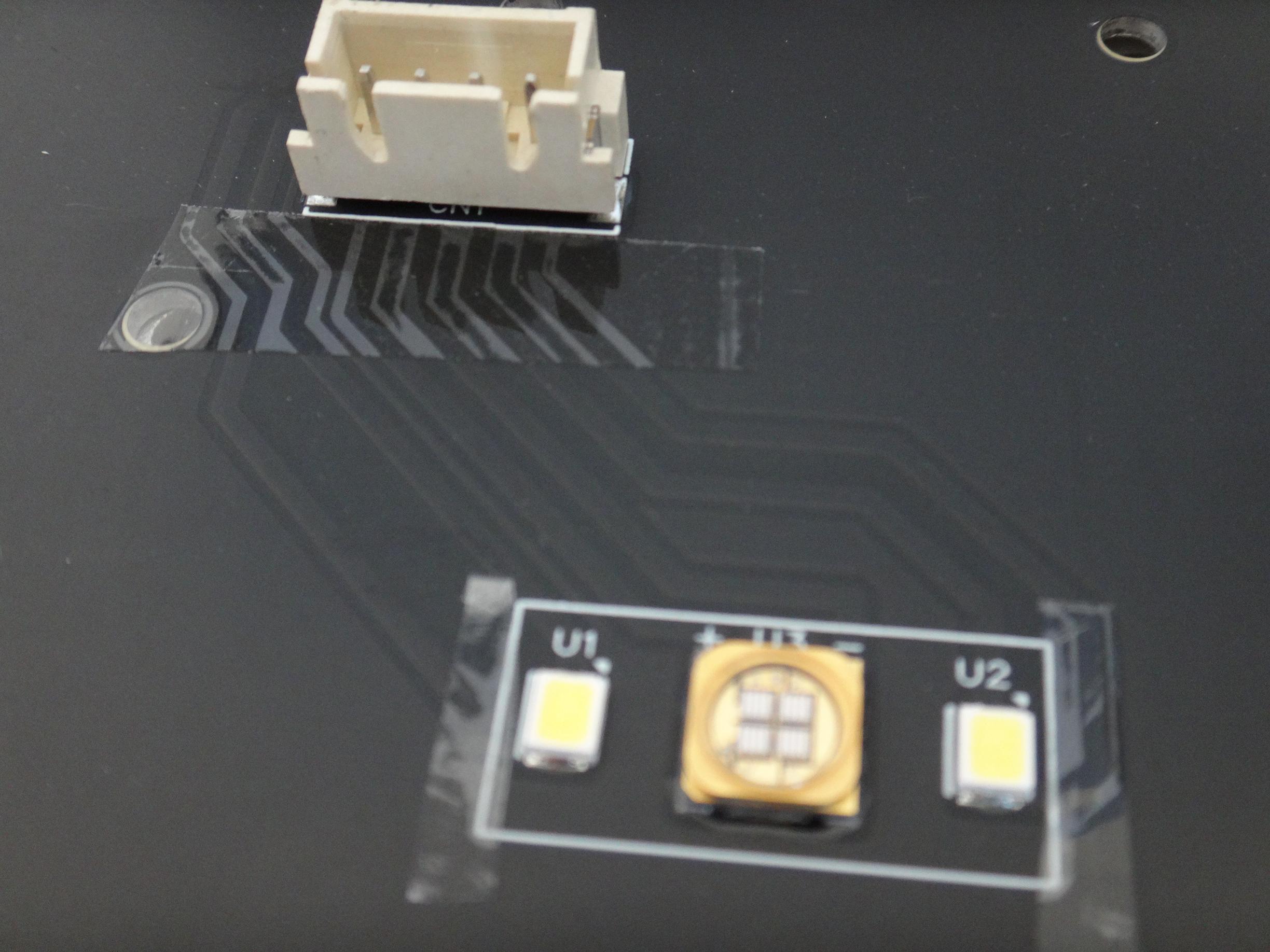 bottom plate of the printer with paths powering the leds covered protected with tape. Time will show whether the tape resists the heat emitted by the leds.